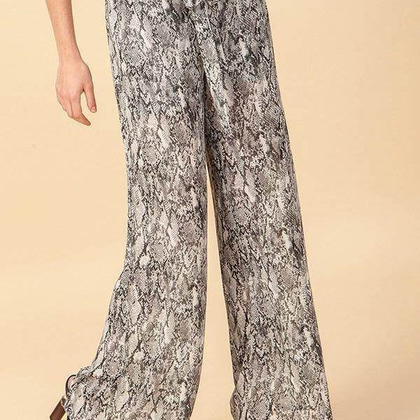 Fashion model wearing snake print wide leg pants with waist tie, showcasing a stylish look.